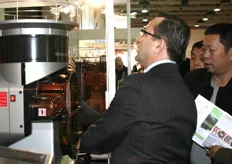 Jorge Pérez Laffont muestra a los visitantes el funcionamiento del equipamiento automático para el exprimido de zumo.